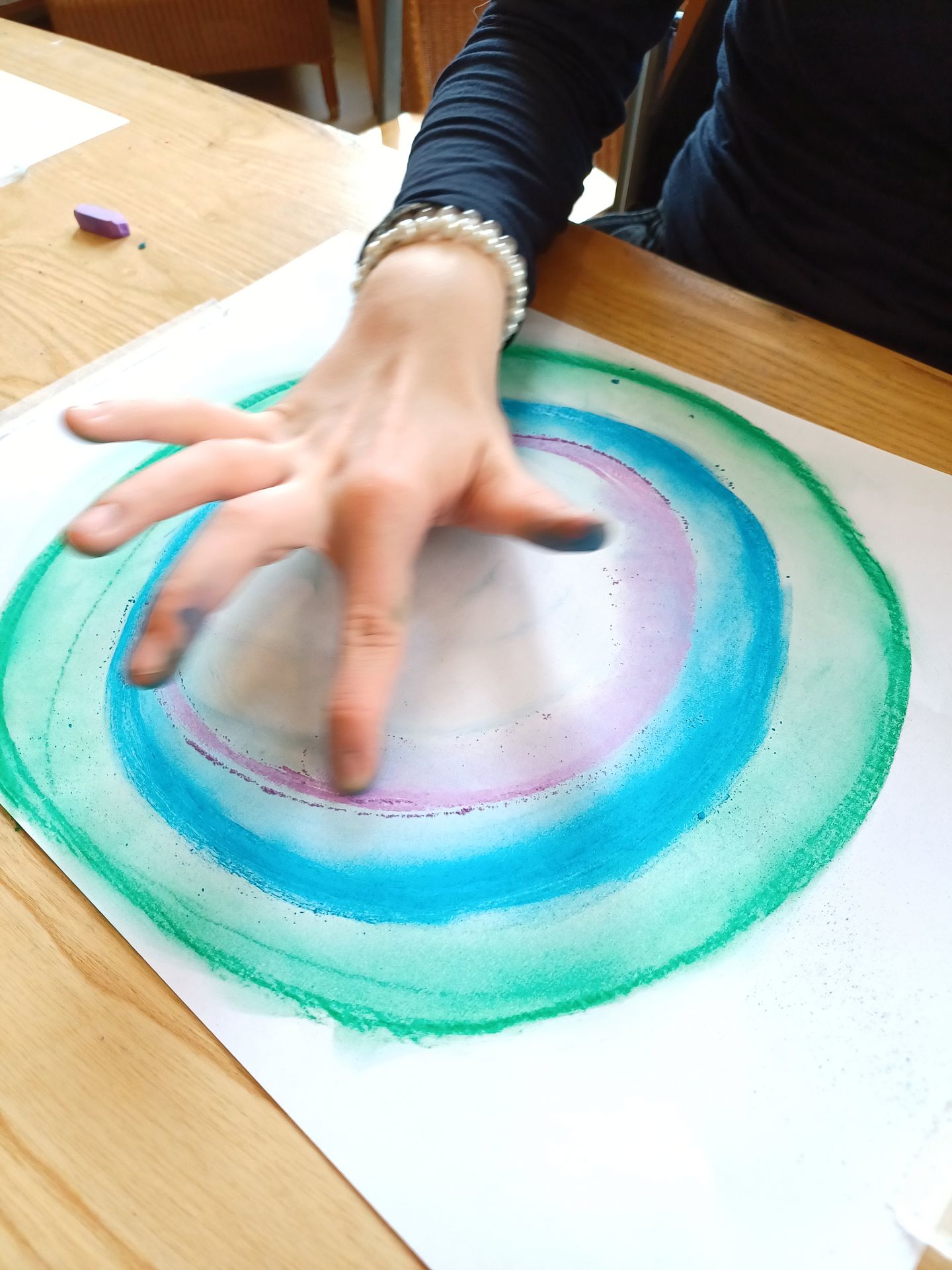 hand dat aan het vingerverven is op een blad papier