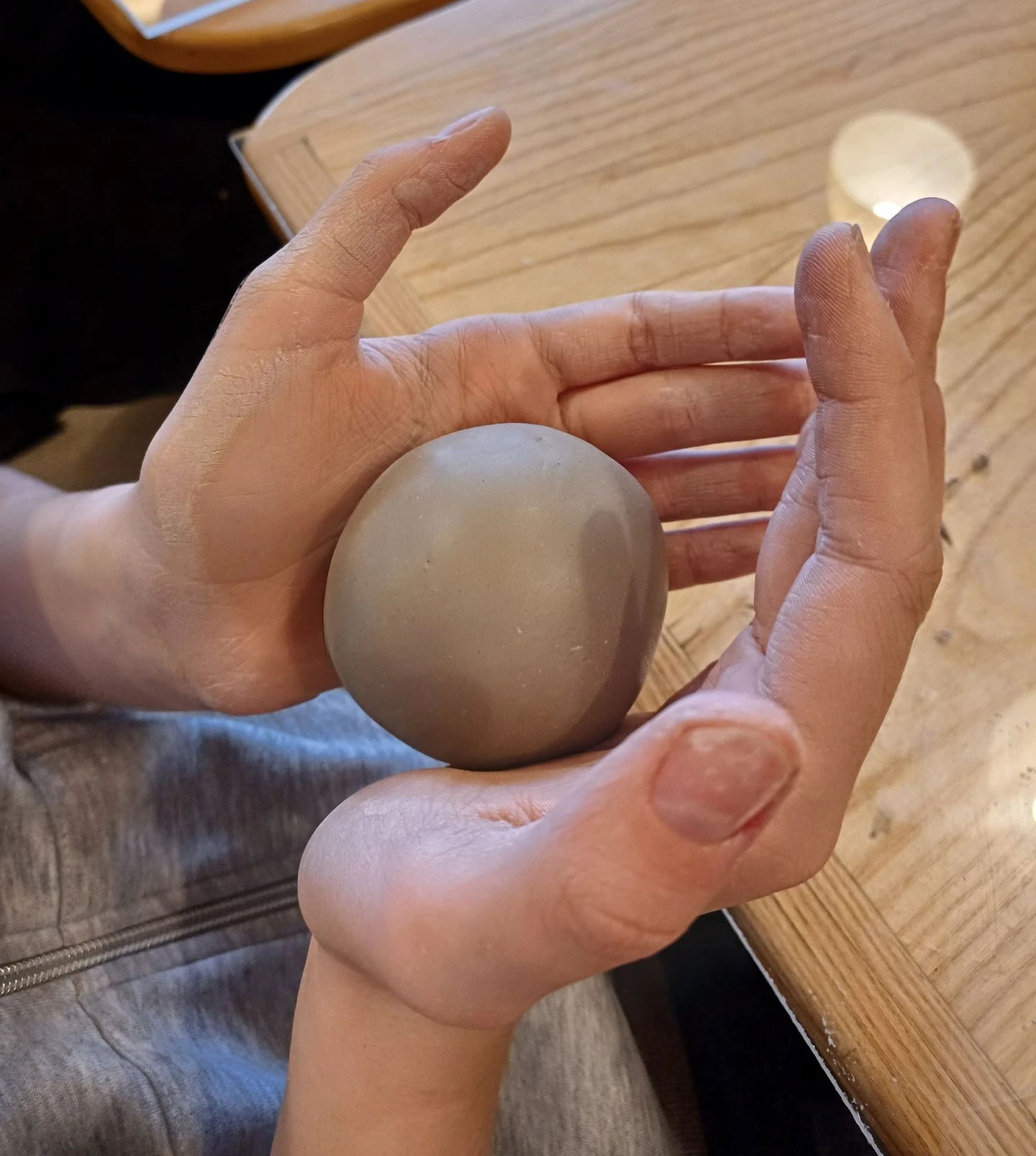 Handen die klei vasthouden